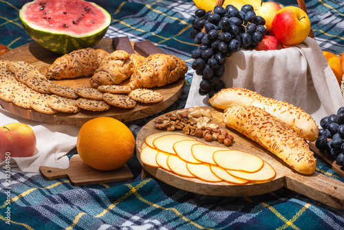 View of different food for summer picnic on checkered blanket, closeup with selective focus. The concept of summer outdoor recreation on the weekend