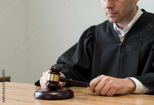Judge in black robe holding...