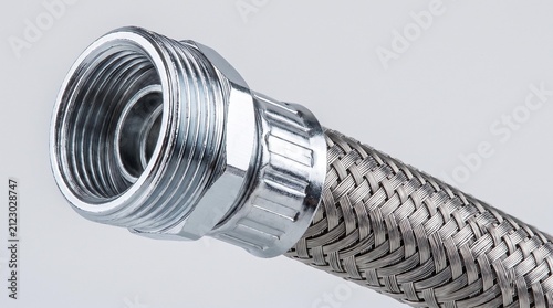 Chrome-plated hydraulic hose fitting with flexible braided metal on a neutral background.