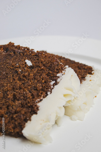 Close-up of two slices of plum cake stacked on top of each other, with white frosting.