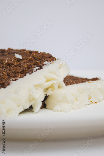 Close-up of two slices of plum cake on a large, blurred plate.