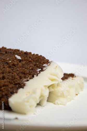 Close-up of two slices of plum cake on a large plate against a white background.