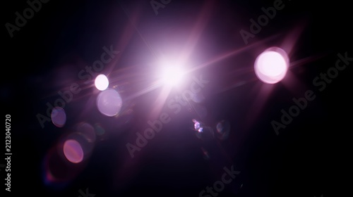 Vibrant purple starburst lens flare on dark background. Magical glowing light leak overlay for creative photo editing and design.