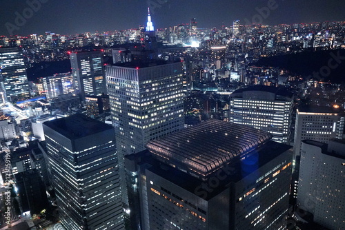 Foto 夜の東京・新宿エリアの超高層ビル群を俯瞰した都会的な夜景、ライトアップされた近代的なオフィスビルと輝く街の灯りが広がる展望。