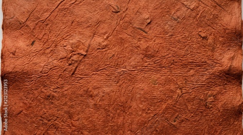 Richly textured brick colored handmade paper with visible fiber grain, fine creases, wrinkles, and subtle organic imperfections on rough surface macro photography background