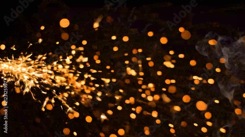 Glowing golden sparks flying against a black background