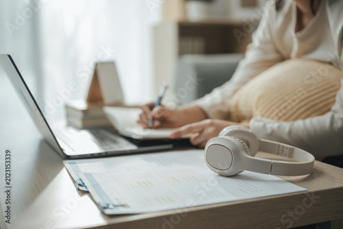 financial research, laptop, and writing notes shape this practical household finance scene. It conveys practical choices, organized planning, everyday money management, and financial awareness.