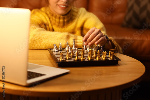 Young woman playing chess o...