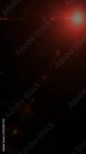 Orange glowing lens flare on dark black background