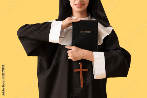 Young nun with Bible on yel...