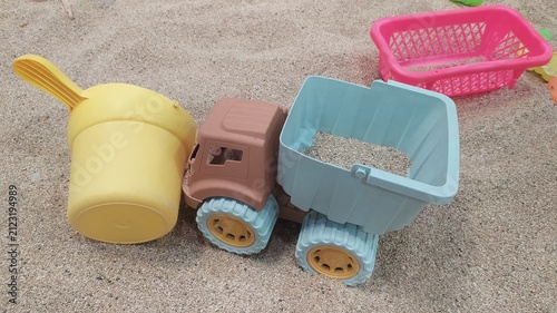 Foto Colorful Plastic Toy Dump Truck and Bucket on Sand,
Kids Beach Toys Plastic Dump