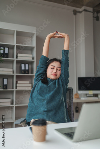Woman stretching arms overhead for relief from work fatigue