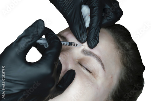 woman lies in an armchair, receiving a cosmetic injection, a close-up of a rejuvenating injection in the forehead,
