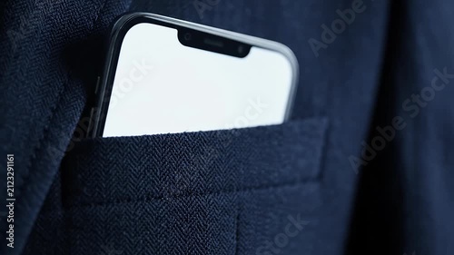 White smartphone screen visible in dark suit jacket pocket.
