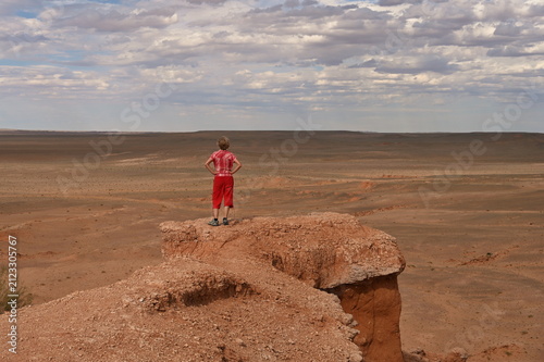Rear view of mature woman standing on the rim of Bayanzag (Flaming Cliffs) in Mongolia