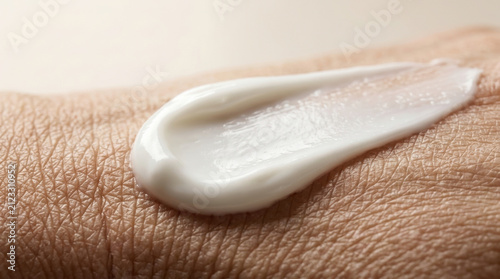 Macro shot of white moisturizing face cream applied on human skin representing anti aging skincare routine, dermatology treatment, and cosmetic body care.