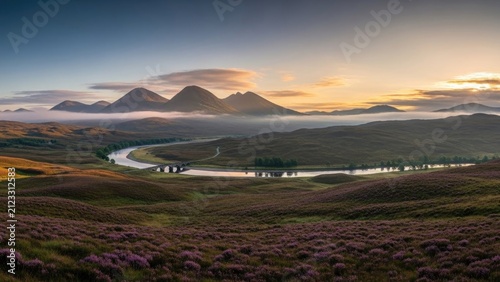 Scottish highlands landscape at dawn; heather blooming with low fog and mountains