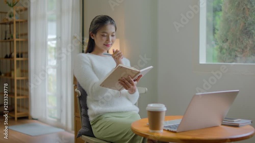 woman writing diary planning on notebook at home