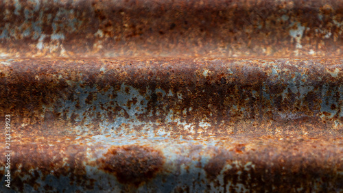 Close up of rustic rusty corrugated metal zinc sheet texture background.A detailed close-up shot of a heavily weathered and rusty corrugated zinc iron sheet. 