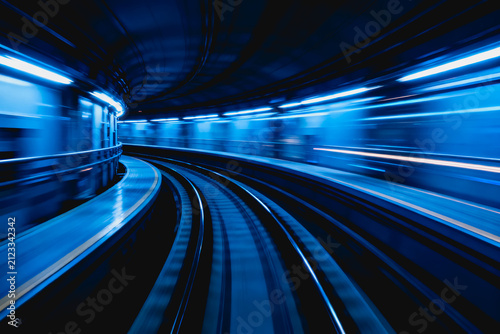 Curved subway tracks in an underground station, captured with motion blur to emphasize speed and urban transit design.
