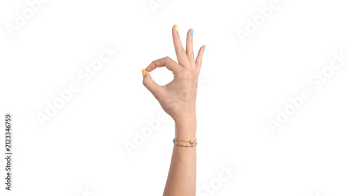Woman’s hand making a crossed-fingers good luck and OK Sign gesture with pastel nails and a delicate bracelet, isolated on a transparent background