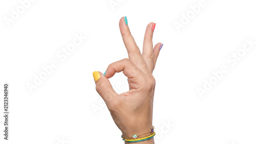 Woman’s hand making an OK sign with bright colorful nails and stacked bracelets, isolated on a transparent background