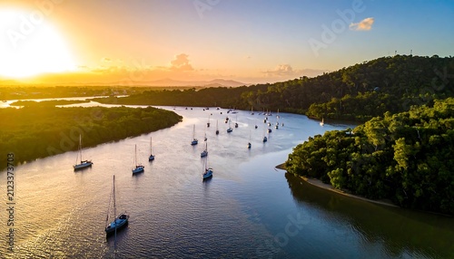 A serene aerial view of a winding river with sailboats and lush greenery at sunset