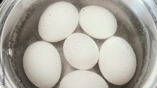 Six chicken eggs boiling in a pan. Boiling water. Cooking in the kitchen.