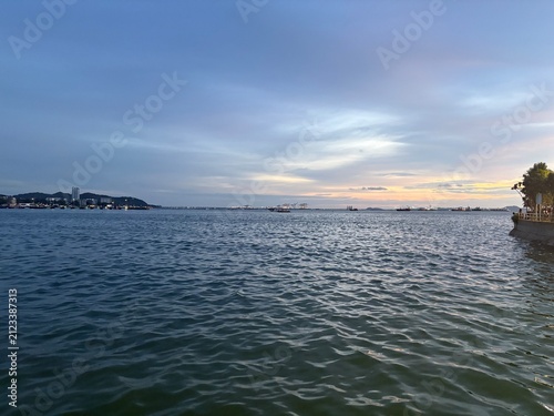 Blue hour seascape with boats and coastal skyline in Si Racha, Thailand
