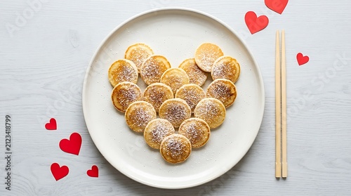 Gold coins arranged in a heart shape on a white plate