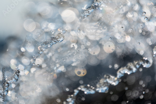 Splashes and jets of water against light background.