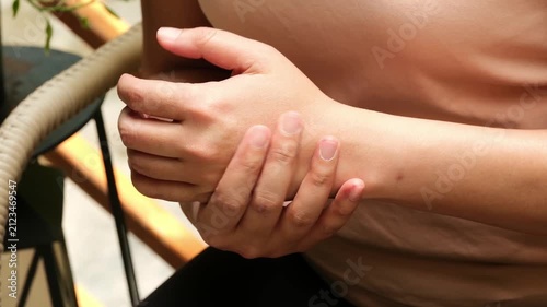 A woman holding their painful hand and numbness, concept of joint pain, injury, or inflammation, highlighting the importance of medical attention, proper care, and orthopedic recovery.	
