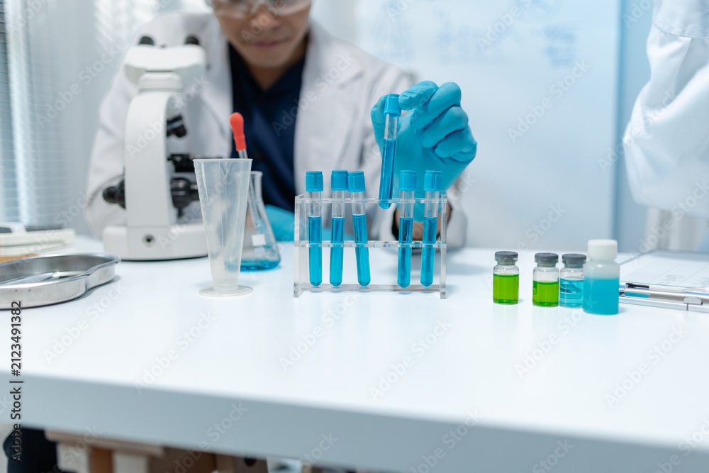 Fototapeta premium Scientists analyze liquid samples using test tubes, microscopes, and laboratory equipment, representing biotechnology, medical diagnostics, research, and healthcare innovation.