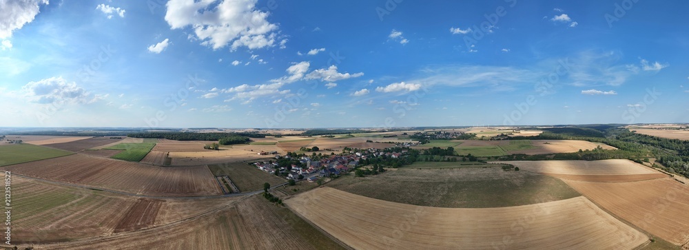 Fototapeta premium vue aérienne panoramique en Meurthe-et-Moselle, le village de Bazailles, entouré de champs et de forêt en août 2026. Lorraine, France