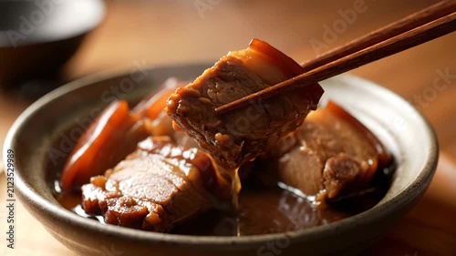Close-up of braised pork in a bowl, close-up of braised pork picked up with chopsticks