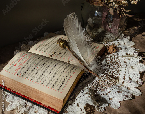 Quadro su tela Vintage spiritual still life with antique hymn book, feather and dried bouquet