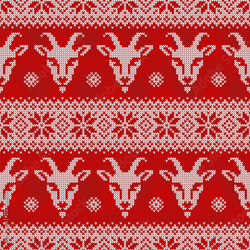 Knitted seamless pattern for 2027 New Year of the Goat. Vector background with goat faces and scandinavian ornaments. Red and white sweater print.