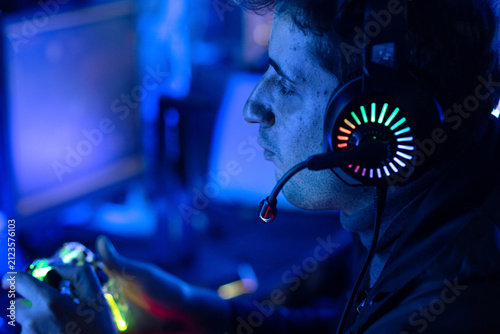 Konstfotografi Male gamer is playing online video games or competing in esports, in a neon-lit