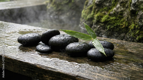 Black Spa Stones with Bamboo Leaf on Wet Wood, Serene Zen Relaxation Concept.