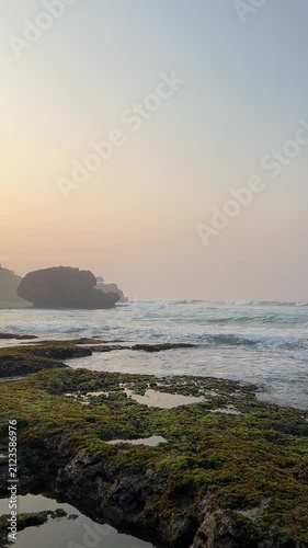 Golden Hour Ocean Waves Crashing on Rocky Shore with Coastal Landscape