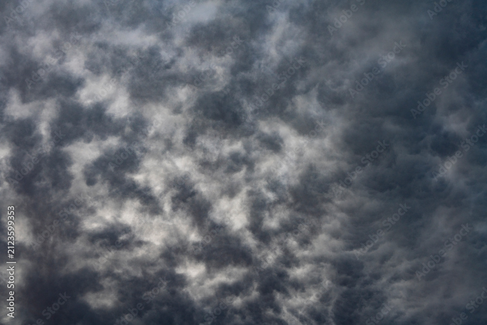 Fototapeta premium Dramatic dark storm clouds abstract background. Heavy grey storm clouds filling the sky before rain, creating dramatic, moody abstract texture of overcast weather