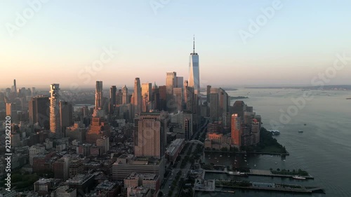Aerial Drone footage of New York City Skyline Downtown Financial District One World Trade Center at sunrise, summer time, pull back shot with pan , opener , reveal footage, Golden Hour 4K 60fps