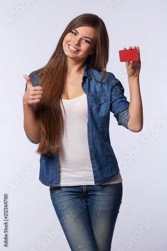 Canvas Print Smiling Young Woman Holding Blank Red Card and Giving Thumbs Up