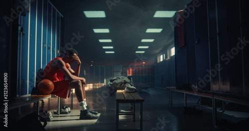 Obraz na płótnie Upset African American Male Basketball Player Sitting Alone on Locker Room Bench
