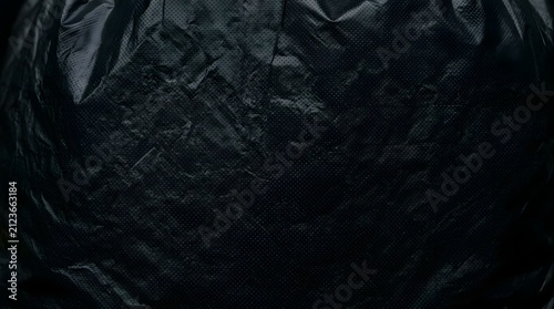 Dark moody black plastic trash bag texture with a subtle dot matrix grid