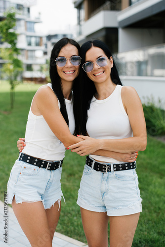 Twin Women Smiling and Hugging Outdoors Together