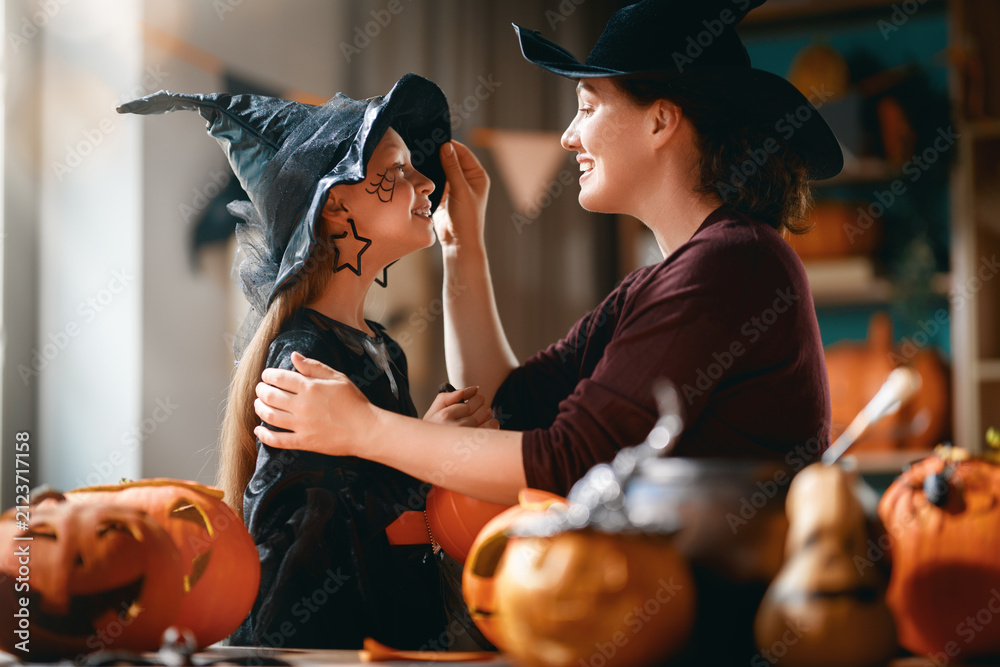 Obraz premium Happy Family Halloween Celebration at Home with Mother and Daughter