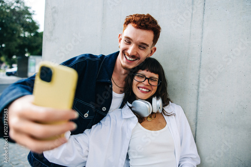 Happy couple taking a selfie together with friends