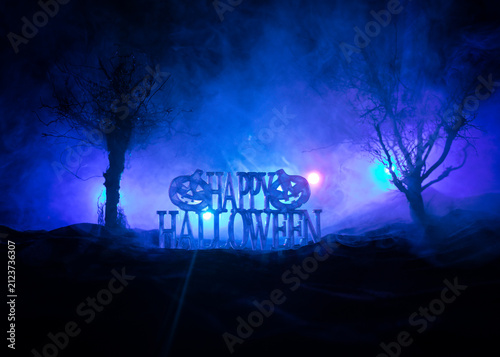 Halloween concept. Creepy silhouette in the dark corridor with pumpkin head. Toned light with fog on background.