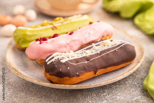 Glazed Eclairs on brown concrete on brown concrete, side view, close up, selective focus